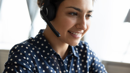 Smiling Indian call center agent consult client online