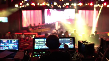 The lighting engineer sets up the controllers on the remote control, checking the lighting schemes.