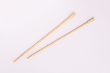 Two chopsticks close up. Wooden chopsticks on a white background.