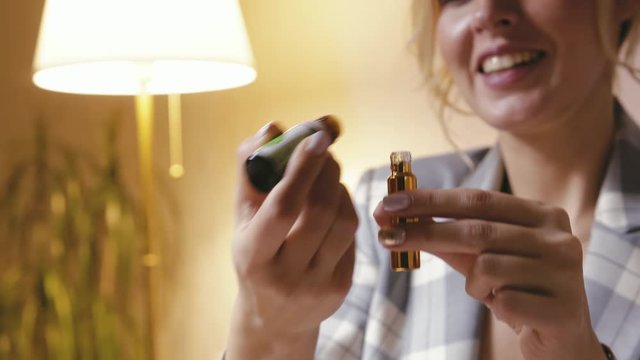 A woman perfumer drops drops of cosmetic, essential oil into a perfume bottle close-up. A falling drop in a dark glass bottle. The concept of beauty spa, aromatherapy