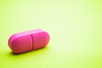 pink pill on a green background