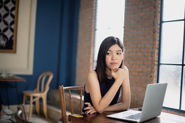 Fototapeta na wymiar Asian freelance girl working at coffee shop with a laptop.