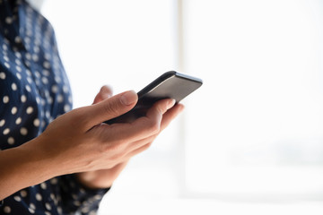 Close up of woman using wireless internet on smartphone gadget