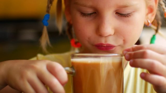 Little girl drinks a hot milk drink and burns hersel