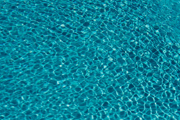 surface of blue swimming pool,background of water in swimming pool sunlight impact
