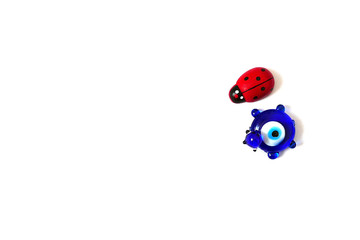 ladybug and evil eye bead on a white background, close up ladybug, evil eye bead and luck