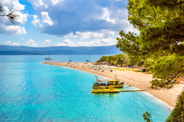 Zlatni Rat beach or Golden Horn in Bol town on Brac Island, Croatia. Scenic pebble beach with pine...