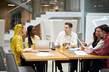 Group of young cheerful people discussing pros and cons of the contract, agreement, close up photo. team is keen on start up business. young people consulting customers