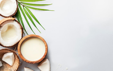 Coconut non dairy vegan milk in wooden bowl. Gray backgound top view with copy space, hard light