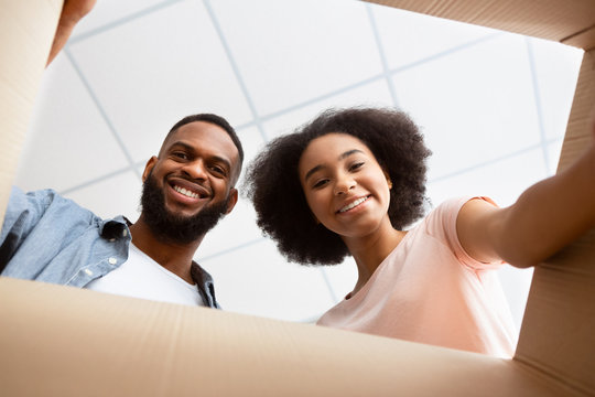 African American Couple Opening Parcel At Home