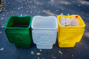 Three trash containers in different color, for sorted waste.
