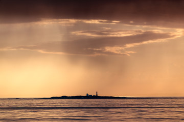 ULSTEINVIK, NORWAY - 2018 MAY 31. Grasoyane lighthouse with sunset and rain same time.