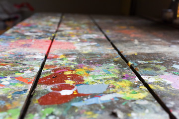 Artists workshop or studio bench covered with splattered paint built up in authentic texture on...