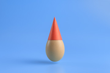 Obraz premium One brown egg in a red festive cap on a blue background. Minimal Happy Easter concept decoration. Copy space for text mockup