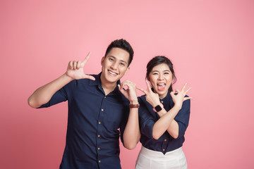 Happy Asian couple doing love hand sign gesture