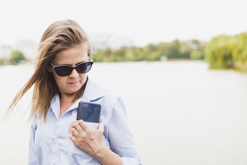 Woman with phone near a lake