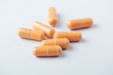 HMB (β-Hydroxy β-methylbutyric acid) capsules. Bodybuilding food supplements on bright paper background. Close up. 