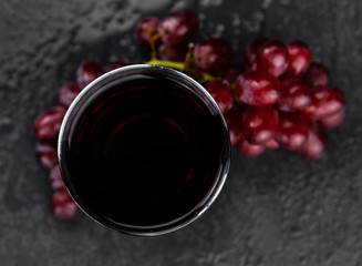 Portion of healthy Red Grape Juice (selective focus; close-up shot)