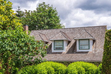 A perfect neighborhood. Houses in suburb at Summer in the north America. Fragment of a luxury house with nice window over blue and white sky.
