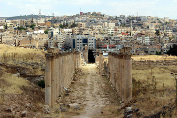 Obraz premium colonnades of the ancient roman city of Jerash and the new city in the background 