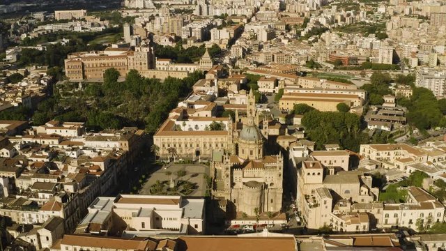 Cinematic flight early sunny morning over the Cattadrale Santa Vergine Maria Assunta, Palazzo dei Normanni, and Cappella Palatina, in the historic part of Palermo. Sicily, Italy. May 2019. Aerial shot