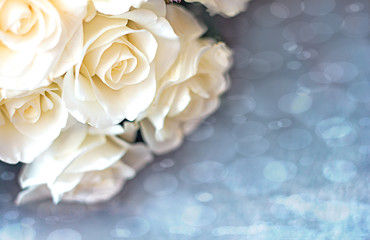 Obraz na płótnie Canvas Greeting card mother's day international women's day on March 8 with a bouquet of white roses in out of focus on a blue bokeh background. Copyspace - Love and Wedding Day concept
