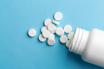 bottle with medicines on a blue table. flat lay for text or logo.Global healthcare concept. Antibiotics drug resistance. Antimicrobial capsule tablets. Pharmaceutical industry.