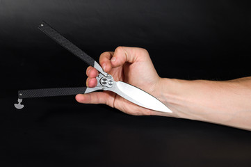 Folding knife with an unusual handle. The knife in the hand.
