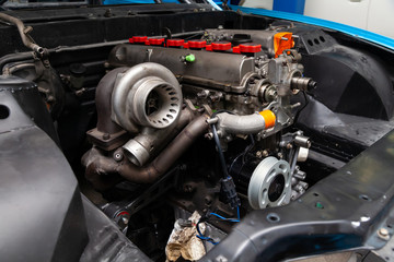 Powerful tuned gasoline engine with a turbocharger and a charger in the engine compartment of an...