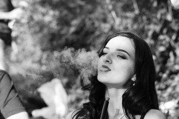 Sexy girl with smartphone smokes hookah