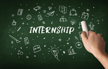 Hand drawing INTERNSHIP inscription with white chalk on blackboard, education concept