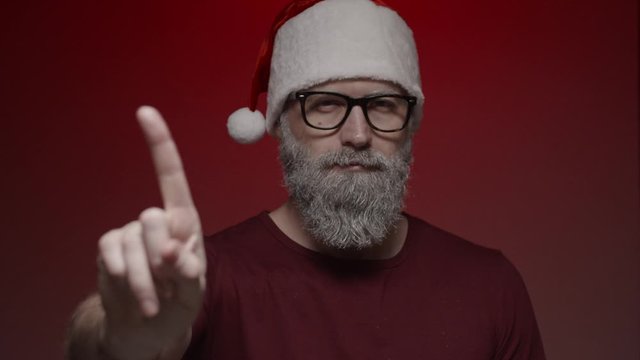 Portrait of Santa Claus making expressions on red background - shows sign of disagreement with finger, slow motion