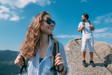 A man and a woman on a rock at a viewpoint in the mountains