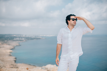 A man on the rocks overlooking the sea