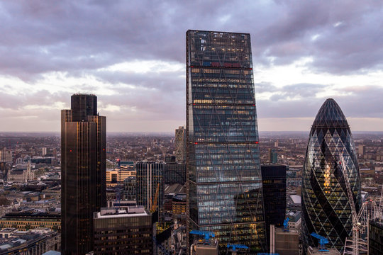 London cityscape at dusk with a prominent skyline featuring the Gherkin - 30 St Mary Axe, Cheesegrater - 122 Leadenhall St and Tower 42 - 25 Old Broad St skyscrapers.