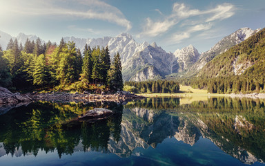 Fototapeta na wymiar Wonderful Nature landscape. Amazing Mountains lake during sunset. Awesome alpine highlands in sunny day. Picture of wild area. Fusine lake. Italy, Julian Alps. Best travel locations.