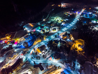 Sheregesh Kemerovo region ski resort in winter, night landscape on mountain and hotels, aerial view