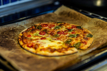 Newly baked pizza with tomato, mozzarella, onion, broccoli and cheese