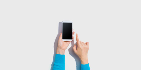 Person using a white smartphone - overhead view