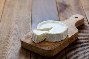 Round cheeses on wooden background isolated. Dark food photo.