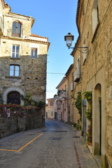 Fototapeta na wymiar Pollica, Italy, 02/15/2020. A narrow street between the old houses of a medieval village in southern Italy