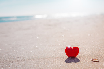 Romantic symbol of red heart on the sand beach