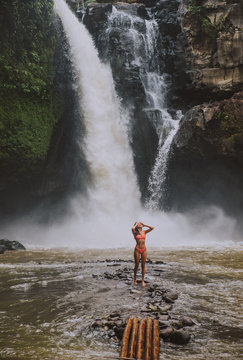 Beautiful girl having fun at the waterfalls in Bali. Concept about wanderlust traveling and wilderness culture