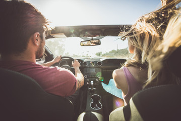 Couple driving on a convertible car - obrazy, fototapety, plakaty