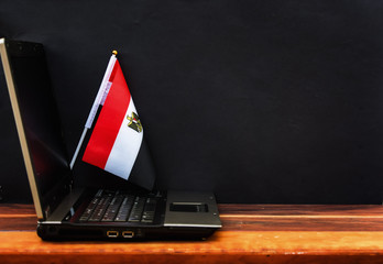  flag of Egypt , computer, laptop on table and dark background