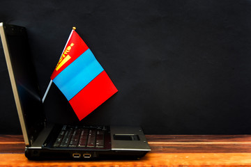  flag of Mongolia , computer, laptop on table and dark background