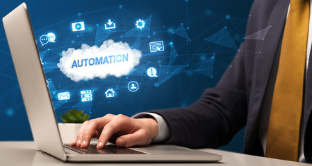 Businessman working on laptop with AUTOMATION inscription, modern technology concept