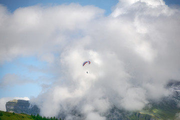 Paraglide flying over a valley in the Swiss Alpine mountains