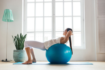 Beautiful girl making training and yoga at home in the morning