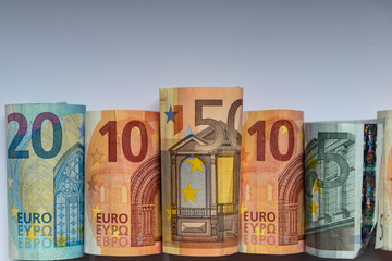 Obraz na płótnie Canvas Beleuchtete und gerollte Euro-Geldscheine aus 20 euro, 50 euro, 10 euro und 5 euro Banknoten zeigen Profit, Gewinn, Ersparnisse und Dividenden im europäischen Finanzmarkt und Währungskursen